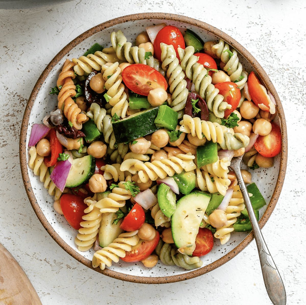 completed Mediterranean Vegan Pasta Salad plated against a white surface
