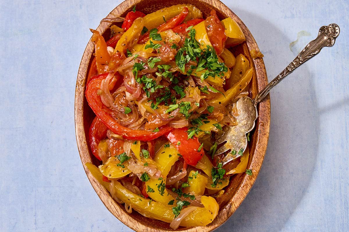 Homemade peperonata in bowl with serving spoon.